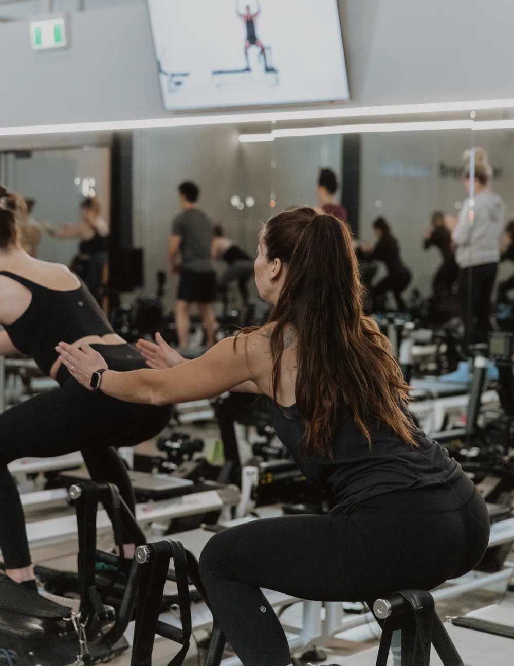 An instructor helping a member with her movement at STRONG Kelowna